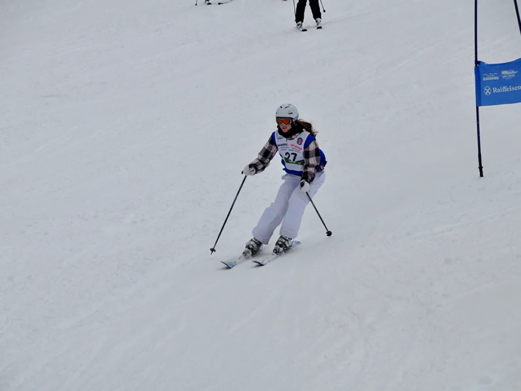 Skifahrerin in weißer Hose zieht einen Schwung.